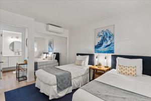 a hotel room with two beds and a bathroom at Lauloa 407 by Coldwell Banker Island Vacations in Wailuku +48 photos