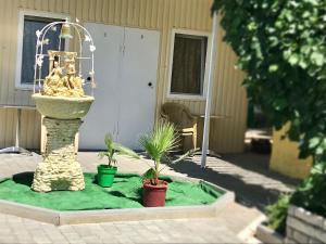 a fountain in a yard with two potted plants at Amio more in Odesa