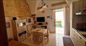 a kitchen with a table and a dining room at Via Cufra 46 in Botrugno +15 photos
