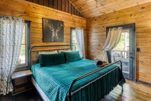 Un dormitorio con una cama en una cabaña de troncos en 3 Suite Peaceful Blue Ridge Cabin, en Mineral Bluff
