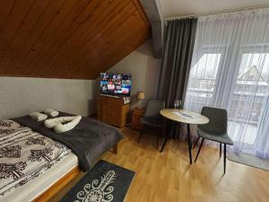 a bedroom with a bed and a table and chairs at Kowali Wierch - blisko Centrum i Dworca PKP in Zakopane