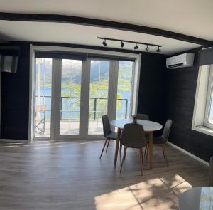 a dining room with a table and chairs and a window at Husslåttene apartments 2 in Skei