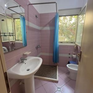 a bathroom with a sink and a toilet and a mirror at Beautiful Villa at Lura 1, Gjiri Lalzit in Durrës