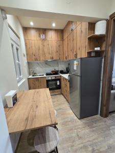 une cuisine avec une table en bois et un réfrigérateur dans l'établissement Phidias House Downtown, à Thessalonique