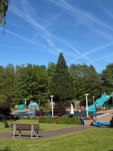 a park with a bench and a water park with slides at Knusperhäuschen mit Sauna in Herschbach