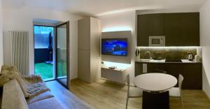 Una sala de estar con una mesa blanca y una cocina. en San Rocco Apartments 2, en Riva del Garda