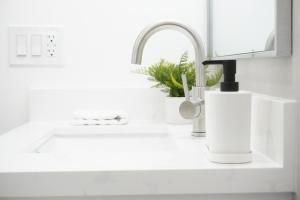 a kitchen counter with a sink and a faucet at Koastal Cove 4beds-3baths 2-kingbeds in Deerfield Beach +19 photos