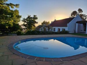 a swimming pool in front of a house at Schalkenbosch Heritage Cottages in Tulbagh