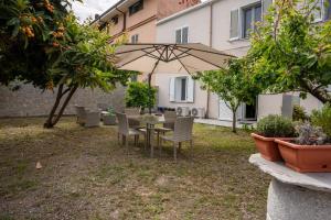 a table and chairs with an umbrella in a yard at Alessandra's apartment in Sassari