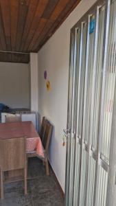 een kamer met een tafel en een tafel en een deur bij Kitnet Praiano- Praia de Olaria in Majé