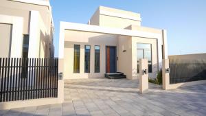 a white house with a black fence in front of it at مجمع شاليهات هيلز in Salalah