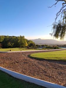 a road leading to a golf course with a grass field at Schalkenbosch Heritage Cottages in Tulbagh