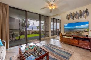 a living room with a large flat screen tv at Milowai 101 by Coldwell Banker Island Vacations in Wailuku
