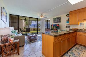a kitchen and living room with a couch and a table at Milowai 101 by Coldwell Banker Island Vacations in Wailuku