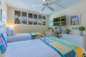 a bedroom with two beds and a ceiling fan at Milowai 101 by Coldwell Banker Island Vacations in Wailuku +50 photos