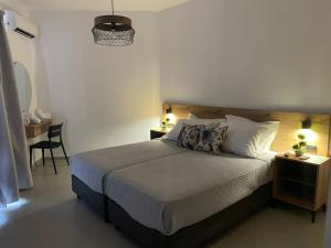 オウランオウポリにあるSENSIMAR Rooms To Letのベッドとテーブルと椅子のある寝室