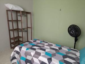 a bedroom with a checkered bed with a fan at Casa Verde Marinho - Sossego no Jacarecanga in Fortaleza