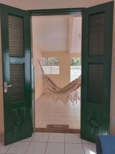 a green door with a hammock in a room at Casa Verde Marinho - Sossego no Jacarecanga in Fortaleza