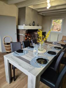 a dining room with a table with chairs and a fireplace at Gite le petit Ely in Thiézac