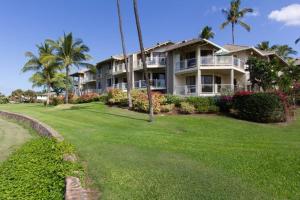 a large house on a lawn with palm trees at Grand Champions 145 by Coldwell Banker Island Vacations in Wailea