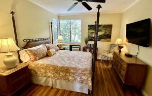 a bedroom with a bed and a flat screen tv at Grand Champions 145 by Coldwell Banker Island Vacations in Wailea +30 photos
