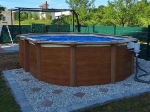 a large hot tub in a yard with a fence at Apartment Nina-bazen-klima-parking in Otočac