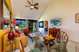 a living room with a ceiling fan and a table at Grand Champions 164 by Coldwell Banker Island Vacations in Wailea