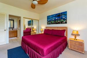 a bedroom with a large bed with a red bedspread at Grand Champions 164 by Coldwell Banker Island Vacations in Wailea +34 photos