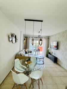 a living room with a glass table and white chairs at Royal Palace- Granada Park in Arona