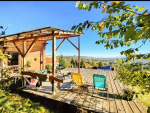 a wooden deck with chairs and a picnic table on it at Tiny House Retreat Bran in Bran