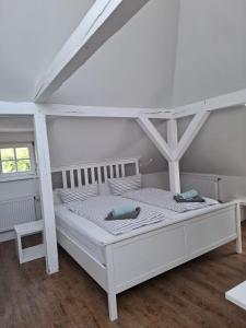 a white bed in a white room with a ladder at Villa 32 in Kröpelin