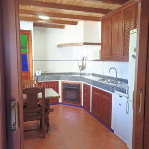 a kitchen with a table and a stove top oven at Casa El Tarajal in Málaga