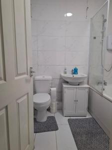 a bathroom with a toilet and a sink and a shower at Sleeps 5 - 2 Bedroom House in Stoke on Trent