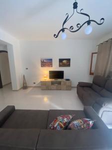 サンタ・フラーヴィアにあるLa casa dei Nonniのソファとテレビのあるリビングルーム