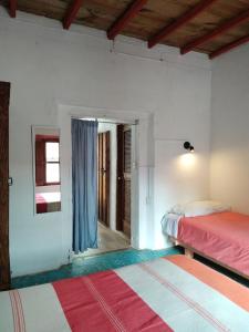 a bedroom with two beds and a hallway with a window at Casa en el Centro de Taxco in Taxco de Alarcón