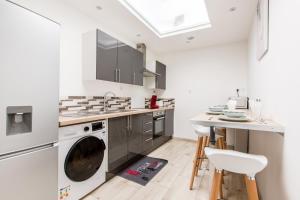a kitchen with a washer and dryer and a table at Cosy house 5 rooms 5 Bathrooms close commodities in Roubaix