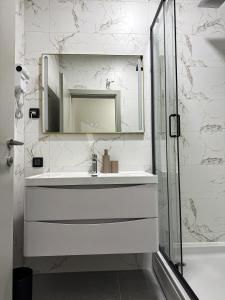 a white bathroom with a sink and a mirror at Alegria Rooms Sarajevo in Ilijaš