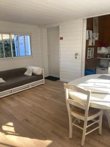 a living room with a bed and a table at AUX PETITS BAGANAIS in Lacanau