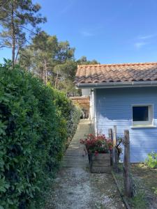 a blue house with a porch and a fence at AUX PETITS BAGANAIS in Lacanau