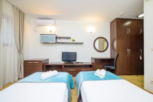 a hotel room with two beds and a mirror at Hotel Odissey Jaz in Budva