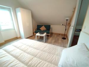 a bedroom with a bed and a chair and a window at Cosne-sur-Loire Appartement Centre Ville in Cosne-Cours-sur-Loire +4 photos
