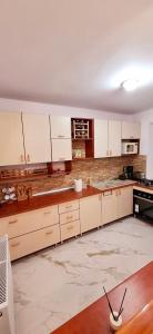 a kitchen with white cabinets and a marble floor at Pensiunea Geo in Lunca Mare +29 photos