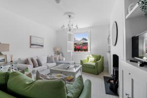 a living room with a couch and a tv at Bay View Luxury Stays - Iris Harbour Cottage in Rodwell