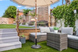 a patio with two chairs and an umbrella at Bay View Luxury Stays - Iris Harbour Cottage in Rodwell