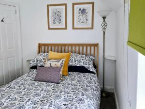 ein Schlafzimmer mit einem Bett mit Kissen und einer Lampe in der Unterkunft Gorgeous Two Bedroom Cottage, Pet Friendly! in Snainton