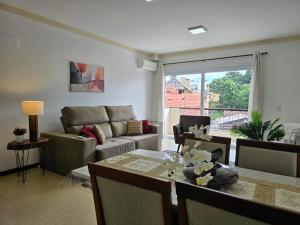 een woonkamer met een bank en een tafel bij Residencial Dona Virgínia Centro in Canela