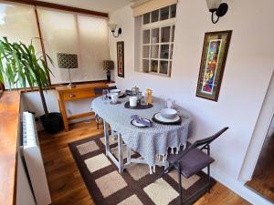 einen Esstisch mit einem blauen Tischtuch darauf in der Unterkunft Gorgeous Two Bedroom Cottage, Pet Friendly! in Snainton