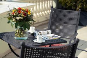 a black table with a vase of flowers on it at Potsdam Hotel Am Jägertor in Potsdam