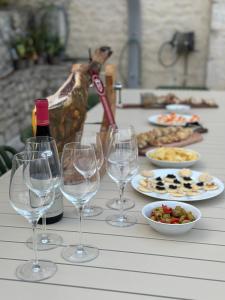 a table with wine glasses and plates of food at Domaine de Péroline Piscine et jacuzzi in Cézac