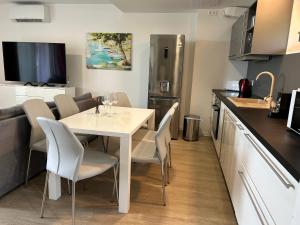 a kitchen with a white table and chairs in a kitchen at Lillawellness Apartman 2 Siófok in Siófok